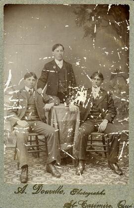 Photographie de trois jeunes hommes dont Roger Dusablon (deux assis, un debout)