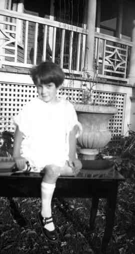 Une fillette assise sur un petit banc