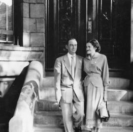 Couple dans les escaliers devant une maison