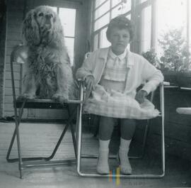 Zita le chien et une petite fille assis sur une chaise