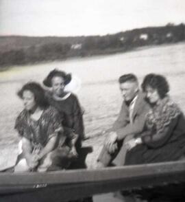 Trois femmes et un homme assis dans un canot