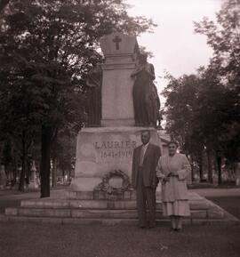 Un couple pose devant une statue de Wilfrid Laurier