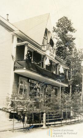 Photo d’une maison, banderole avec W. Tessier écrit dessus