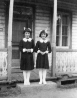 Deux jeunes filles près d'une maison