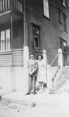 Un homme et une femme dehors devant une maison