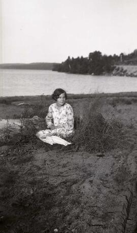 Une jeune femme assise près de l'eau