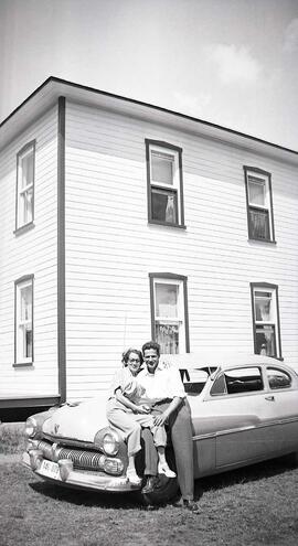 Vachon Irène avec un inconnu assis sur le devant d'une voiture