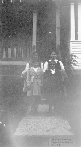 Quatre personnes devant l’entrée d’une maison