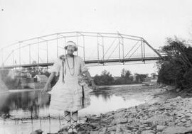Jeune fille en robe blanche près de la rivière près d’un pont