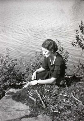 Une femme inconnue assise au bord de l'eau