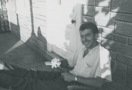 Homme sur une chaise devant l 'entrée d'une maison