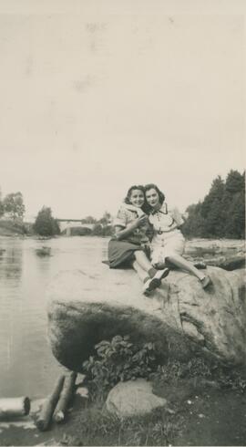Deux femmes assise sur un roche près de l'eau