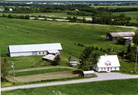 La terre familiale Mayrand. Photographie de la maison et des bâtiments de ferme prise par Gilles Chicoine.