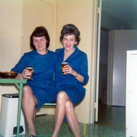 Deux femmes habillées en bleu buvant une bière