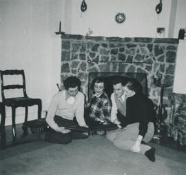 Groupe de personnes près d'une cheminée qui regardent un livre