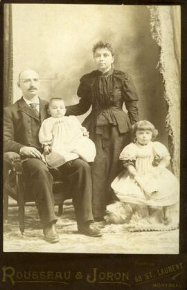 Photographie de famille, 2 enfants et un couple (homme assis et femme debout)