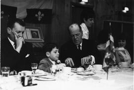 Le Dr Philippe Demers, député de St-Maurice, coupe les mets de l’assiette de Vincent Plamondon (8 ans) sous le regard du Dr Guy Gauthier, député de Berthier