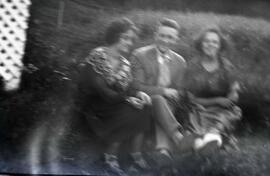 Deux femmes et un homme assis dans l'herbe