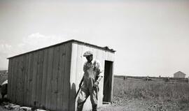 Simard Omer devant une porcherie