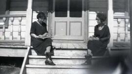 Deux femmes assises dan un escalier extérieur