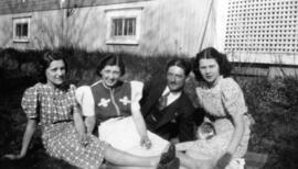 Trois femmes et un homme assis dans le gazon