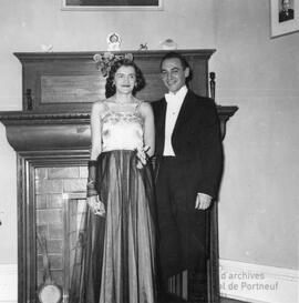 Homme et femme bien habillés devant un foyer