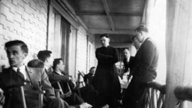 Plusieurs jeunes hommes, dont un curé, qui discutent