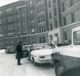 Homme rentrant dans sa voiture devant l’Hôtel-Dieu de Roberval