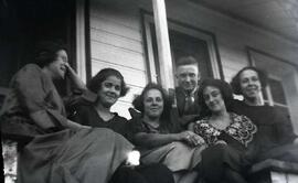 Cinq femmes et un homme assis dans les marches d'un escalier