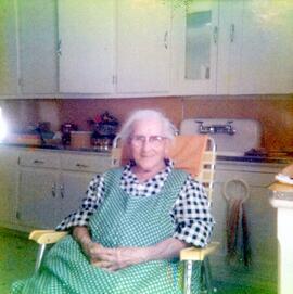 Photo d’une vieille dame assise sur une chaise dans la cuisine