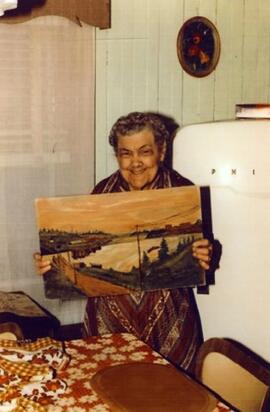 Une femme pose avec une peinture