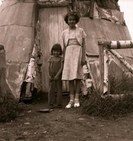 Une femme et une enfant devant un tipi