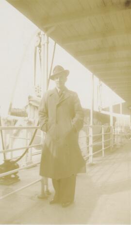 Homme portant un chapeau près d'un bateau