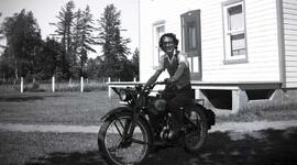 Vachon Irène sur une moto en avant de la maison d'Arthur Vachon