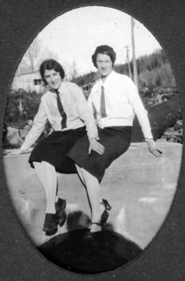 Deux jeunes femmes assises sur le bord d'un pont