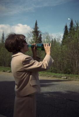 Une femme boit une bouteille de champagne