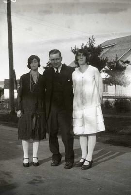 Un homme entre deux femmes inconnues debout sur la route