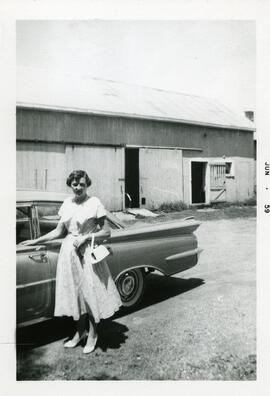 Claudine Vohl à côté d’une voiture devant une grange chez ses parents