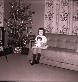 Une fillette avec sa poupée à noël