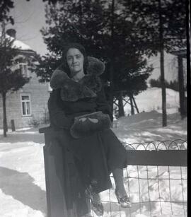 Femme inconnue assise sur une clôture