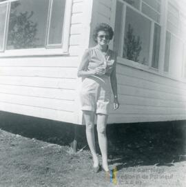 Une femme appuyer sur le coin d’une maison