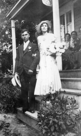 Nouveaux mariés près d'une maison