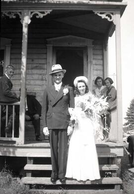 Couple de mariés inconnus dans un escalier devant une maison
