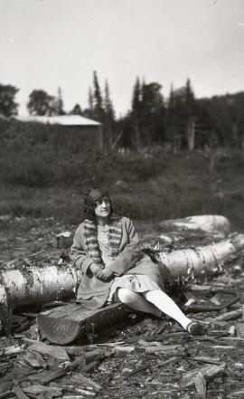 Une femme assise sur un billot