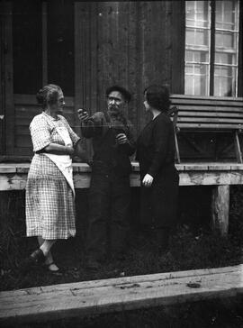 Trois personnes devant un bâtiment