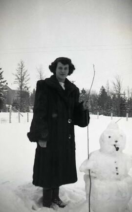 Vachon Rollande à côté d'un bonhomme de neige