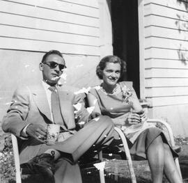 Homme et femme assis dehors buvant quelque chose