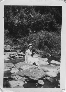Jeune femme assise sur des rochers