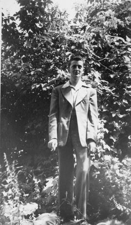 Portrait d’un homme tenant une cigarette dehors devant des arbres
