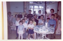 Adrien Vohl et Yvonne L’Écuyer avec leurs petits-enfants dans leur cuisine